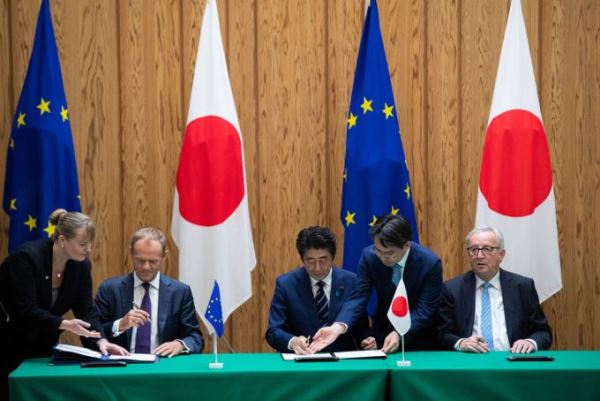 Japanese Prime Minister Shinzo Abe (C) signs an agreement with European Council President Donald Tusk (L) and European Commission President Jean-Claude Juncker (R) at the Prime Minister's Office in Tokyo on July 17, 2018. [Photo: Pool/AFP/Martin BUREAU]
